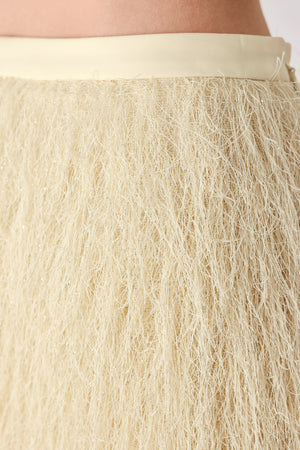 A model wearing a cream-colored, shaggy, textured mini skirt | FREEMARKET