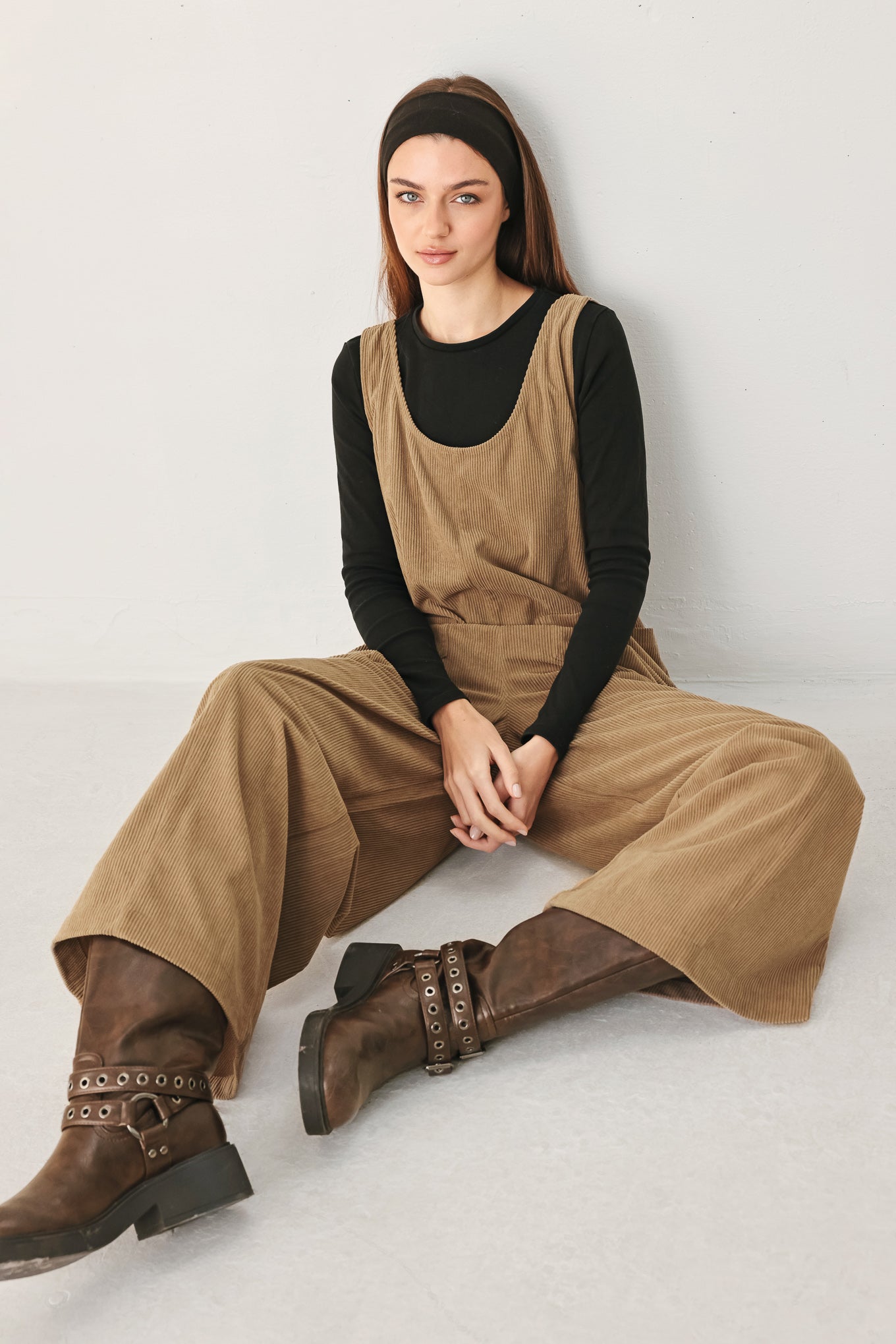 Woman wearing a brown corduroy jumpsuit with U neckline, pockets and adjustable straps | FREEMARKET