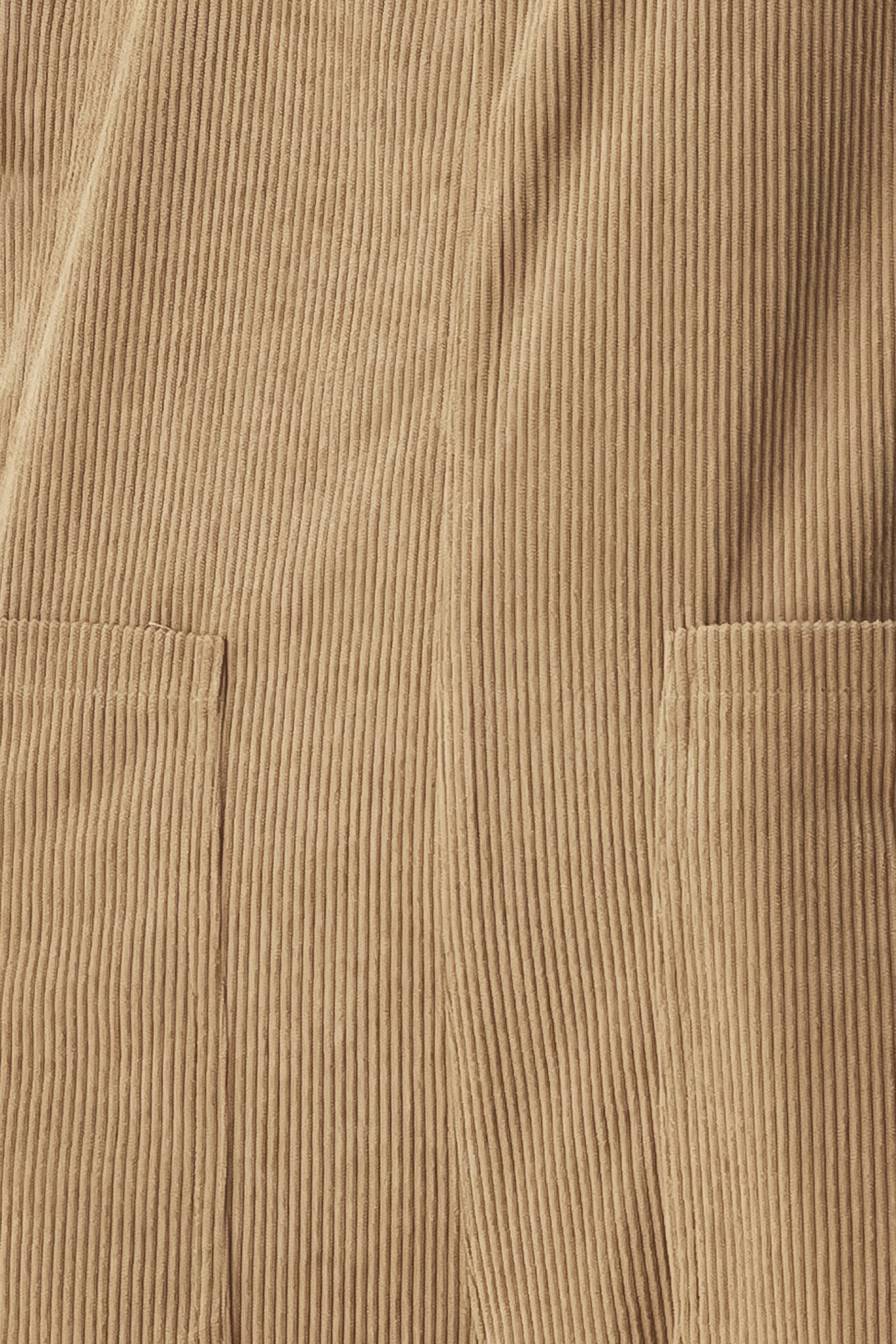 Woman wearing a brown corduroy jumpsuit with U neckline, pockets and adjustable straps | FREEMARKET