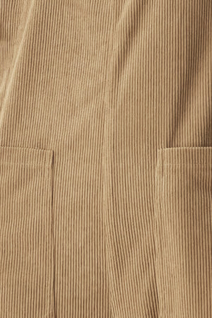 Woman wearing a brown corduroy jumpsuit with U neckline, pockets and adjustable straps | FREEMARKET