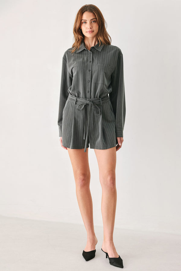 A woman modeling a dark gray pinstriped long-sleeve shirt dress with a tie waist belt | FREEMARKET 