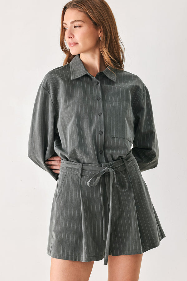 A woman modeling a dark gray pinstriped long-sleeve shirt dress with a tie waist belt | FREEMARKET 