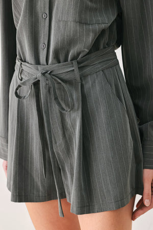 A woman modeling a dark gray pinstriped long-sleeve shirt dress with a tie waist belt | FREEMARKET 