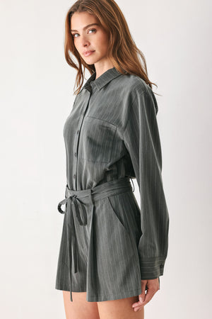 A woman modeling a dark gray pinstriped long-sleeve shirt dress with a tie waist belt | FREEMARKET 