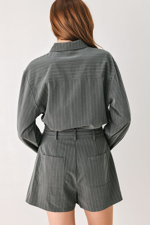 A woman modeling a dark gray pinstriped long-sleeve shirt dress with a tie waist belt | FREEMARKET 