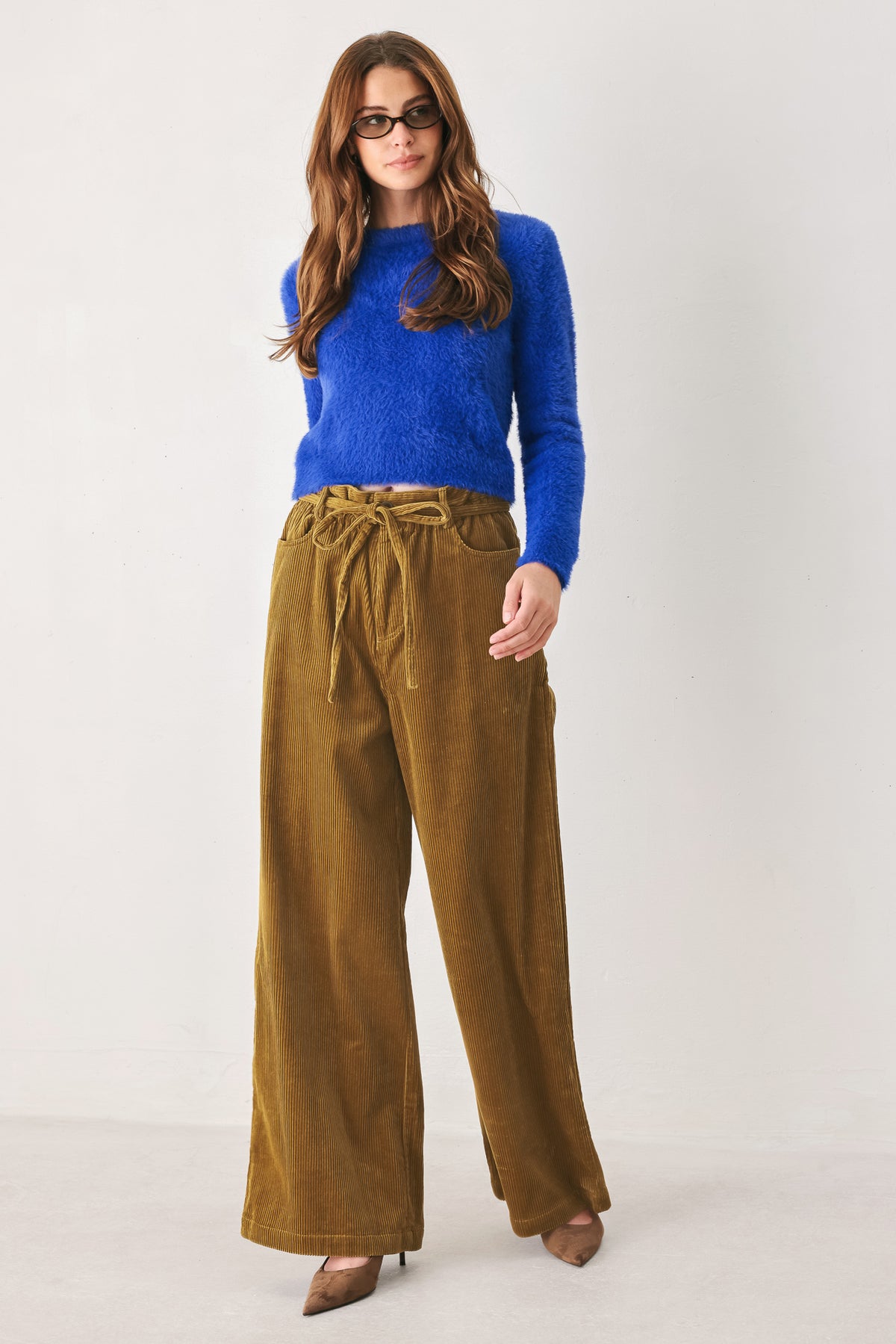 A woman modeling a high-waisted, wide-leg brown corduroy pants with a drawstring waist | FREEMARKET