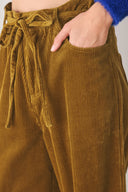 A woman modeling a high-waisted, wide-leg brown corduroy pants with a drawstring waist | FREEMARKET