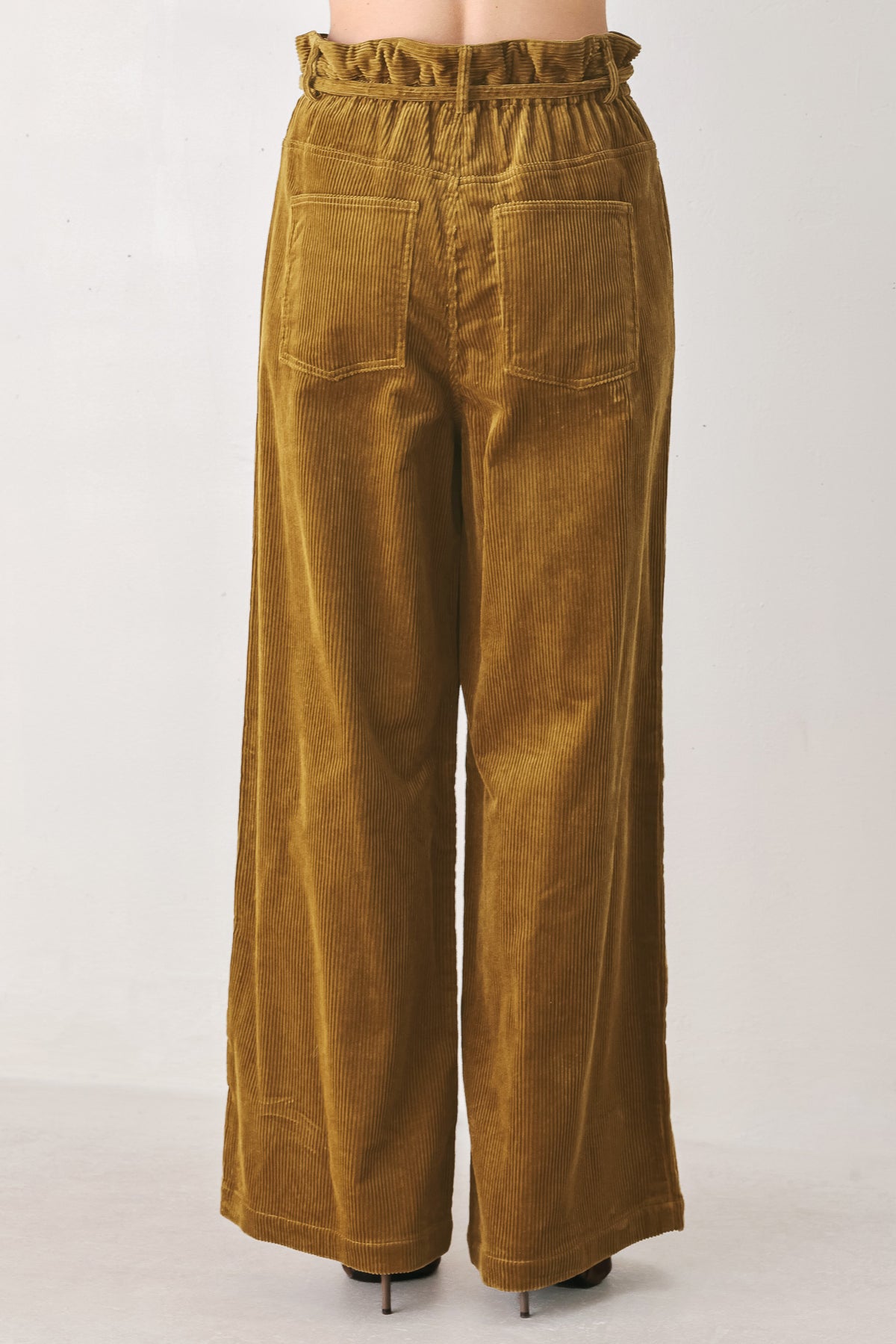 A woman modeling a high-waisted, wide-leg brown corduroy pants with a drawstring waist | FREEMARKET