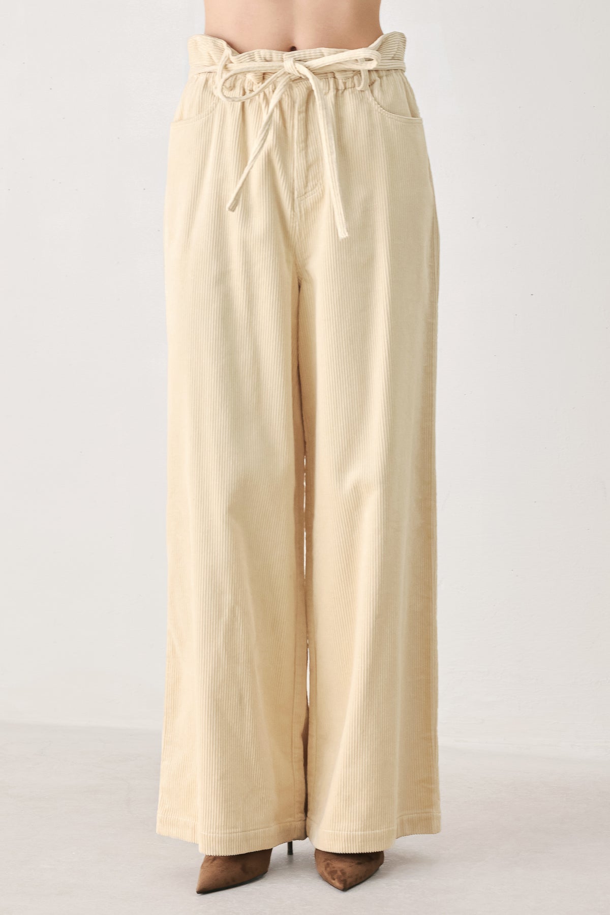 A woman modeling a cream corduroy wide-leg trousers | FREEMARKET