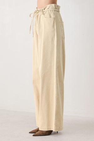 A woman modeling a cream corduroy wide-leg trousers | FREEMARKET