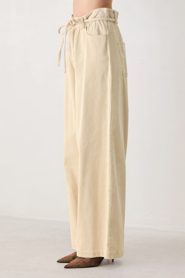 A woman modeling a cream corduroy wide-leg trousers | FREEMARKET