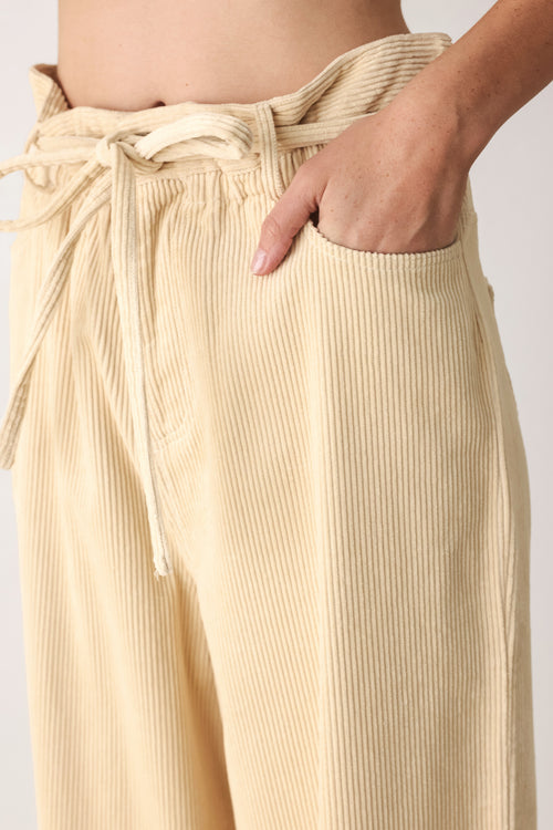 A woman modeling a cream corduroy wide-leg trousers | FREEMARKET