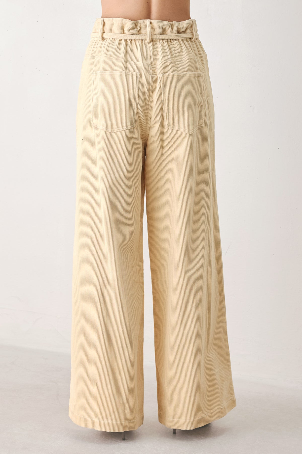 A woman modeling a cream corduroy wide-leg trousers | FREEMARKET