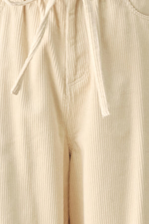 A woman modeling a cream corduroy wide-leg trousers | FREEMARKET