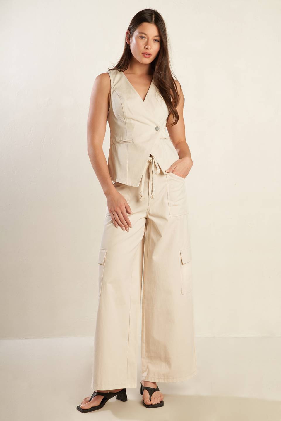 A solid woven pant featuring front closure, contrasting belt, side and cargo pockets and wide leg.