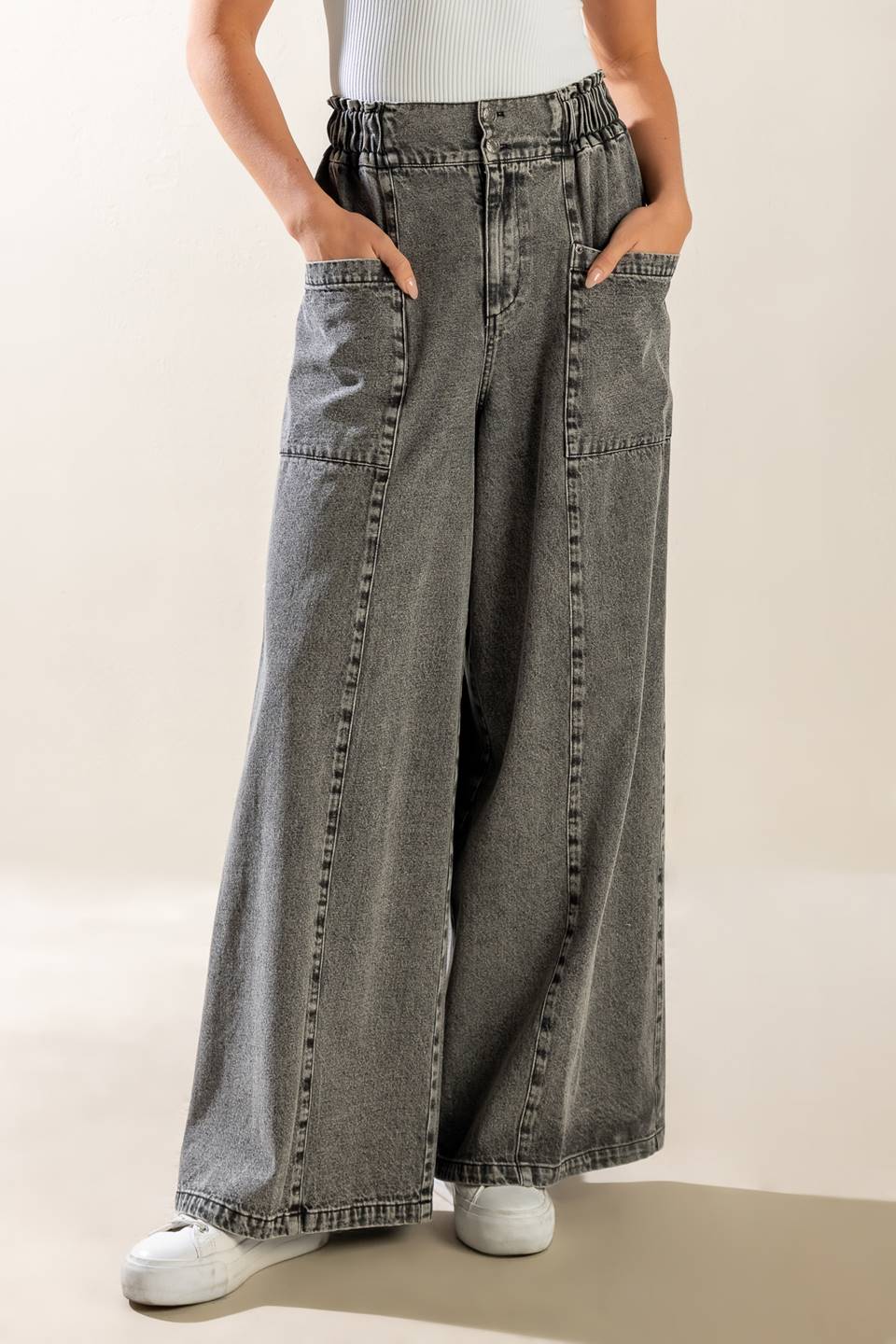 A washed denim pant featuring elasticized waistband, front zipper closure, side pockets and wide leg.