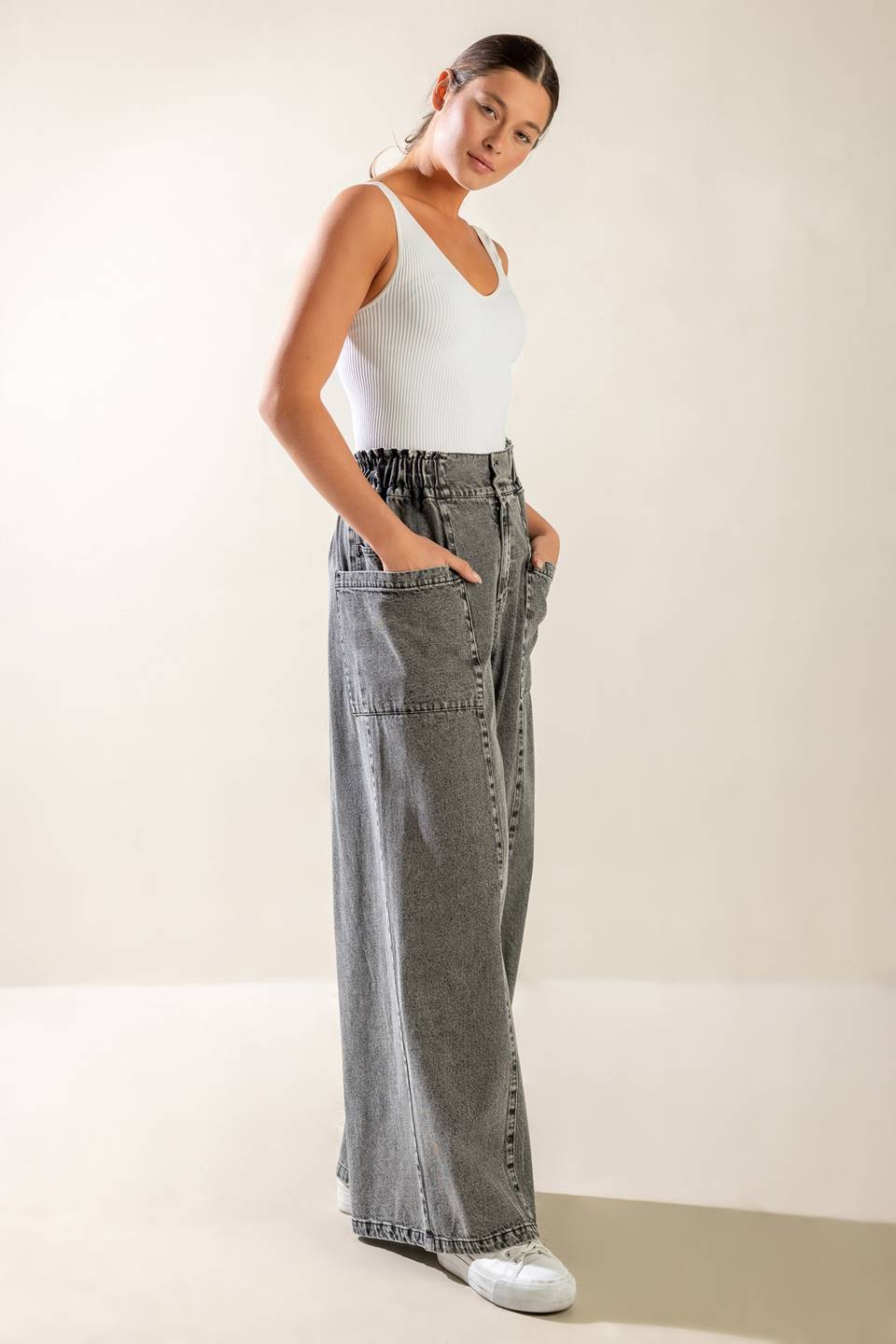 A washed denim pant featuring elasticized waistband, front zipper closure, side pockets and wide leg.