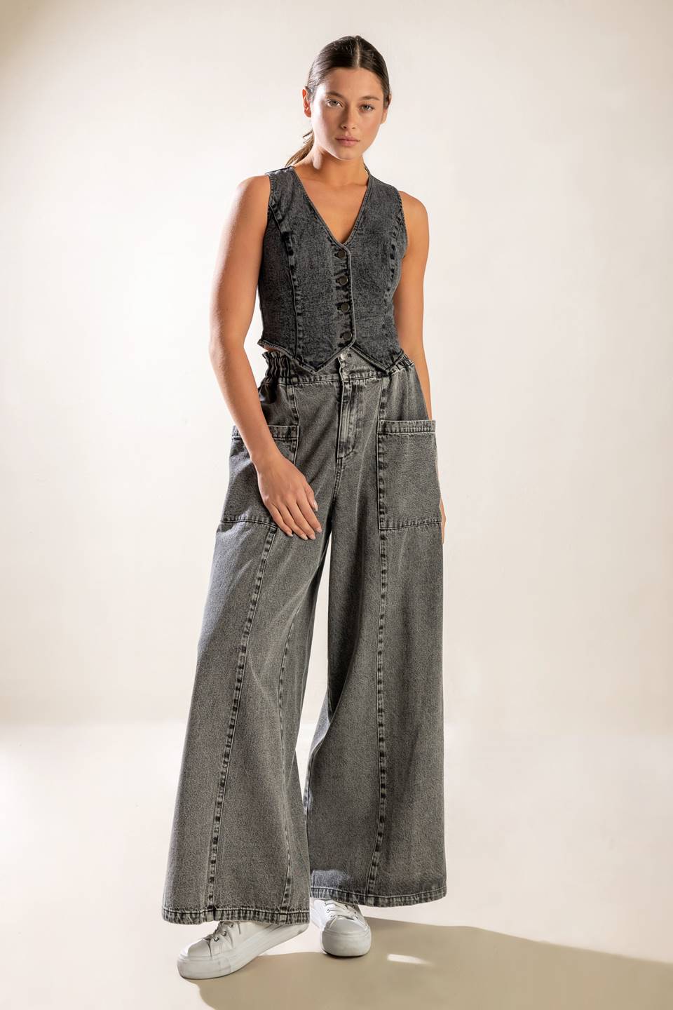 A washed denim pant featuring elasticized waistband, front zipper closure, side pockets and wide leg.