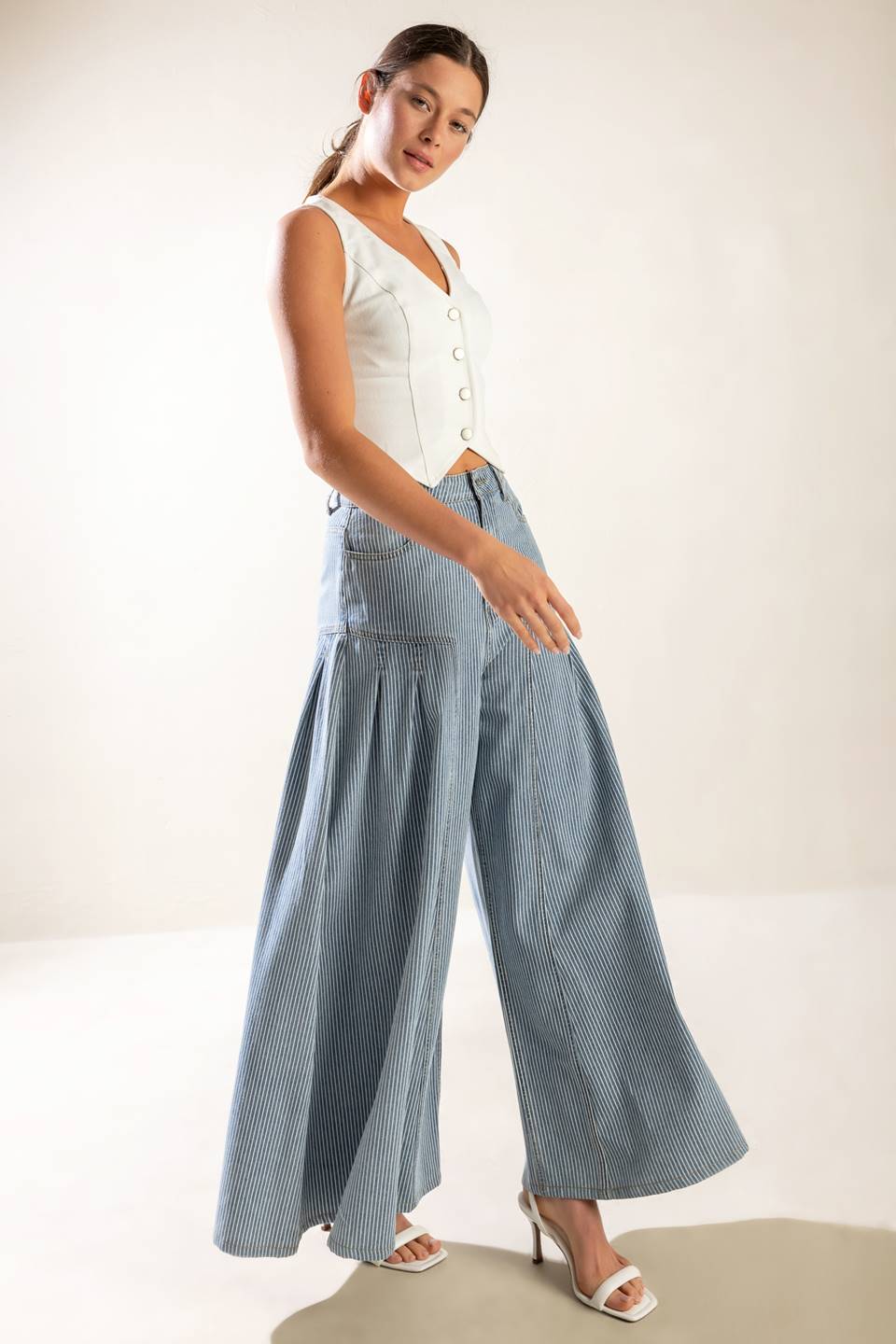 A striped washed high waisted denim pant featuring front closure, side pockets and extra wide leg.