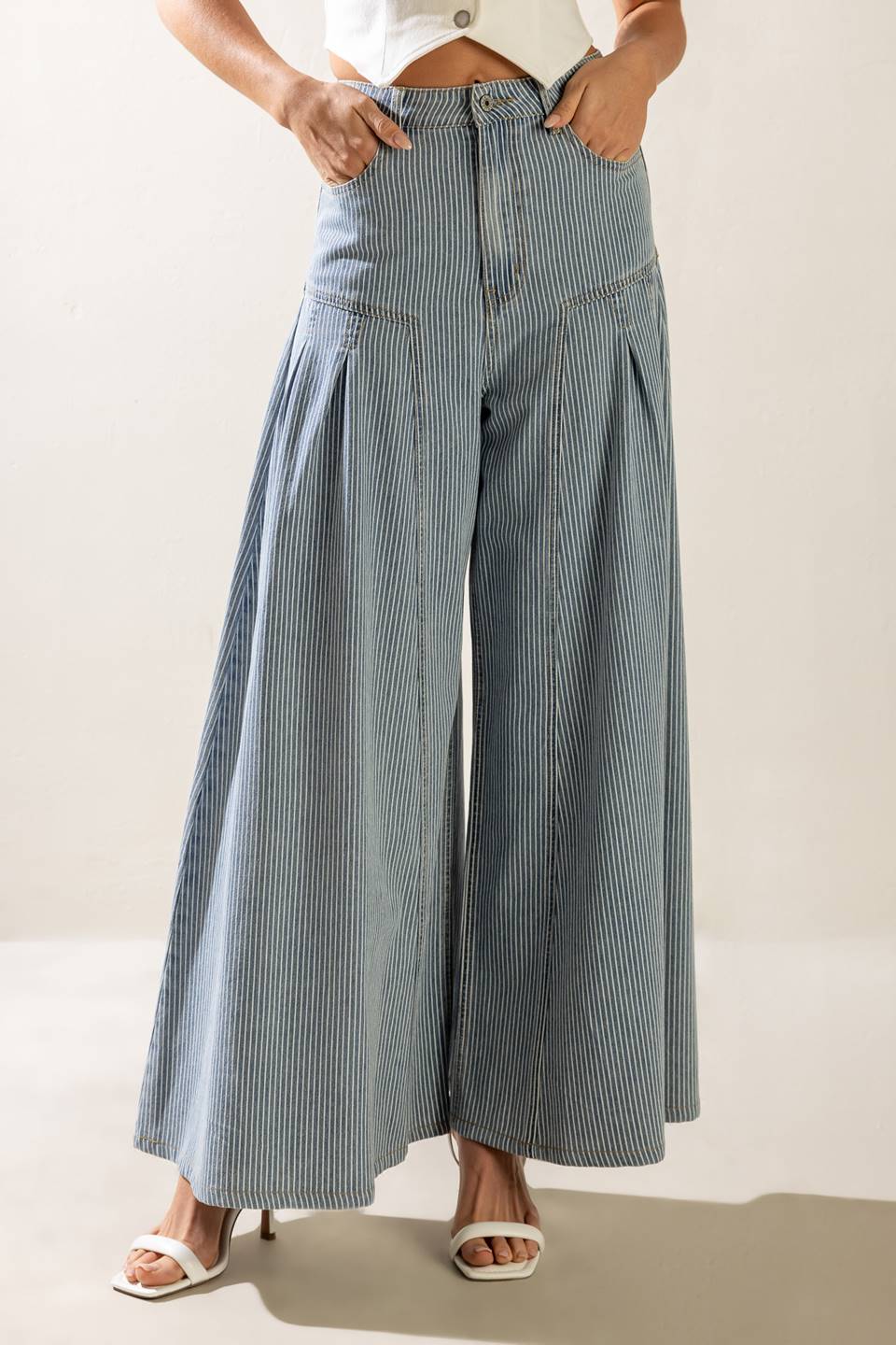 A striped washed high waisted denim pant featuring front closure, side pockets and extra wide leg.