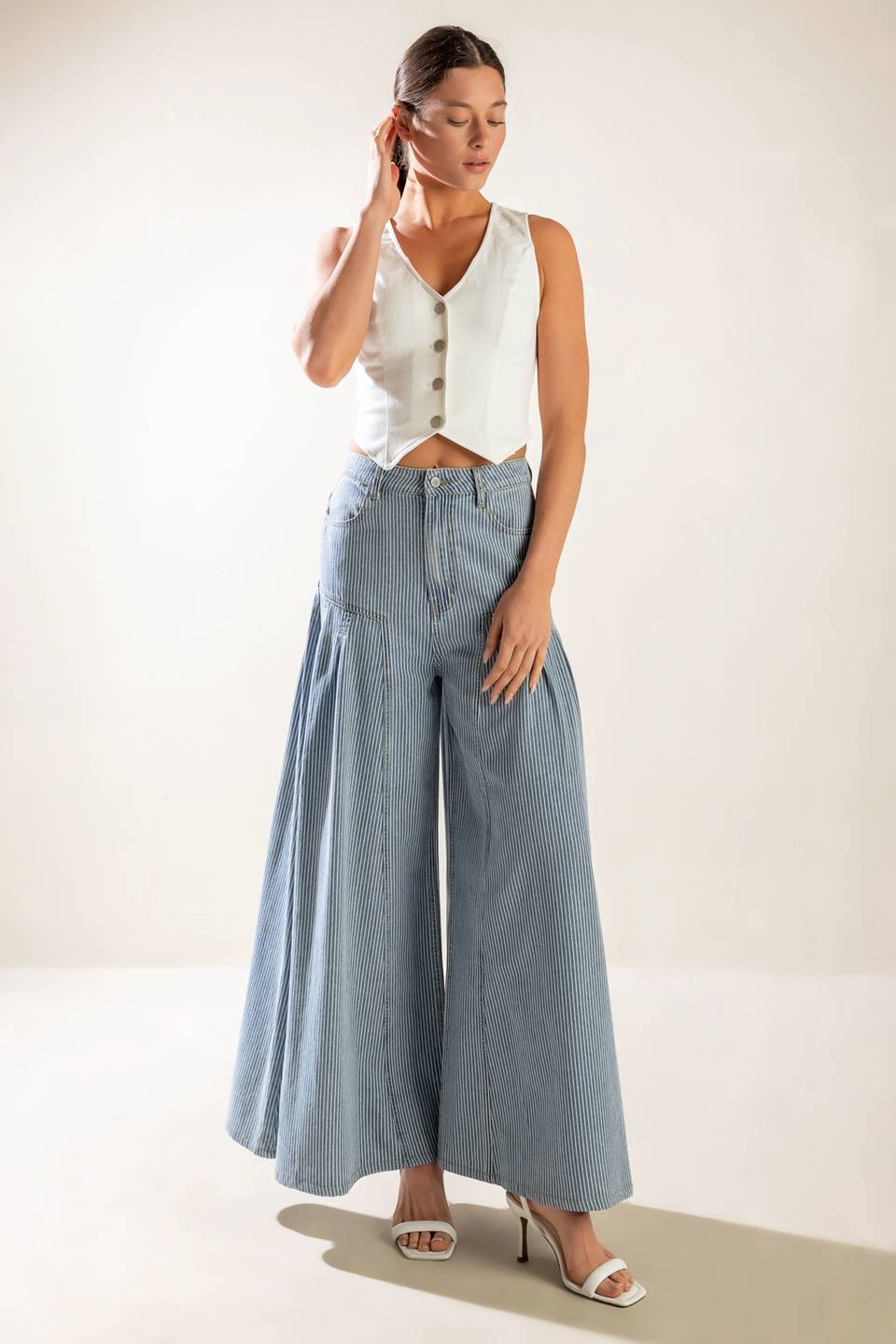 A striped washed high waisted denim pant featuring front closure, side pockets and extra wide leg.