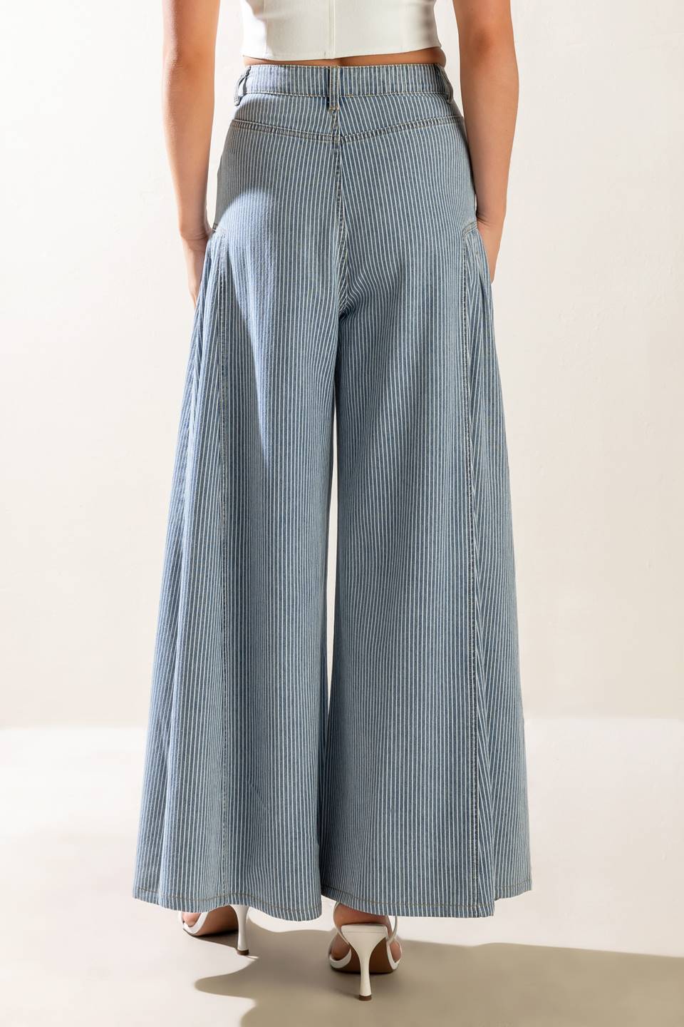 A striped washed high waisted denim pant featuring front closure, side pockets and extra wide leg.