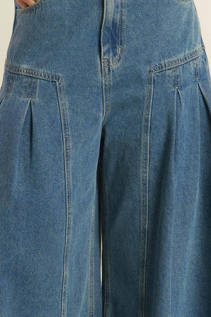 Effortlessly styled with a washed denim finish, these pants include a front closure, side pockets, pleated detailing, and a wide leg for added comfort.