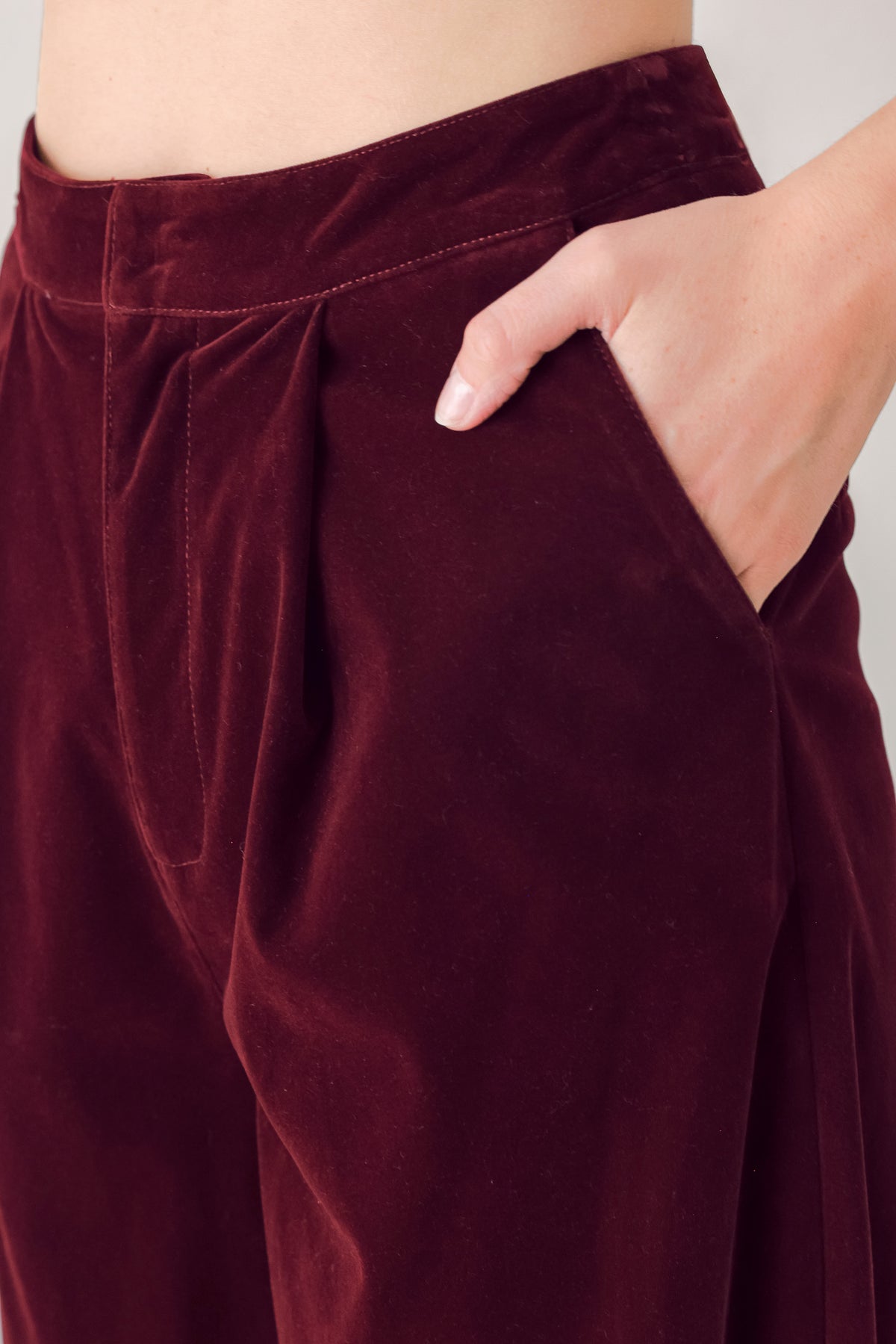 A person wearing high-waisted, wide-leg burgundy velvet pants with black pointed-toe heels | FREEMARKET