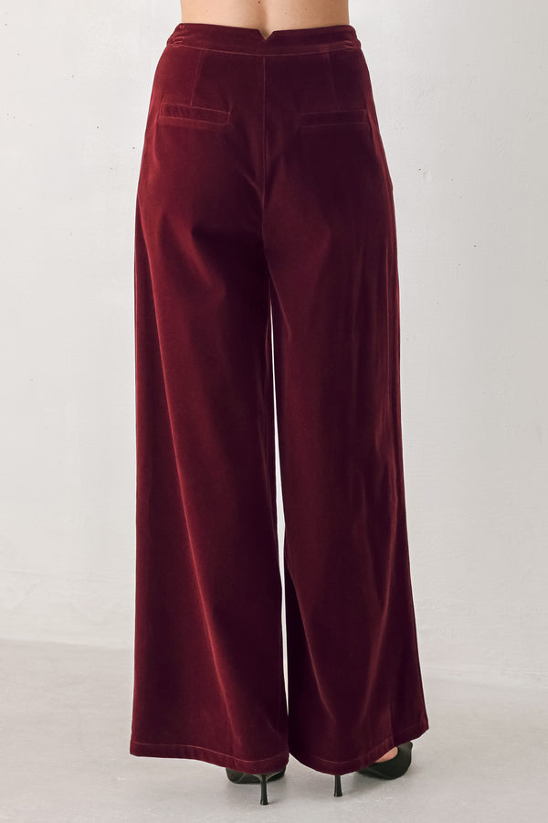 A person wearing high-waisted, wide-leg burgundy velvet pants with black pointed-toe heels | FREEMARKET