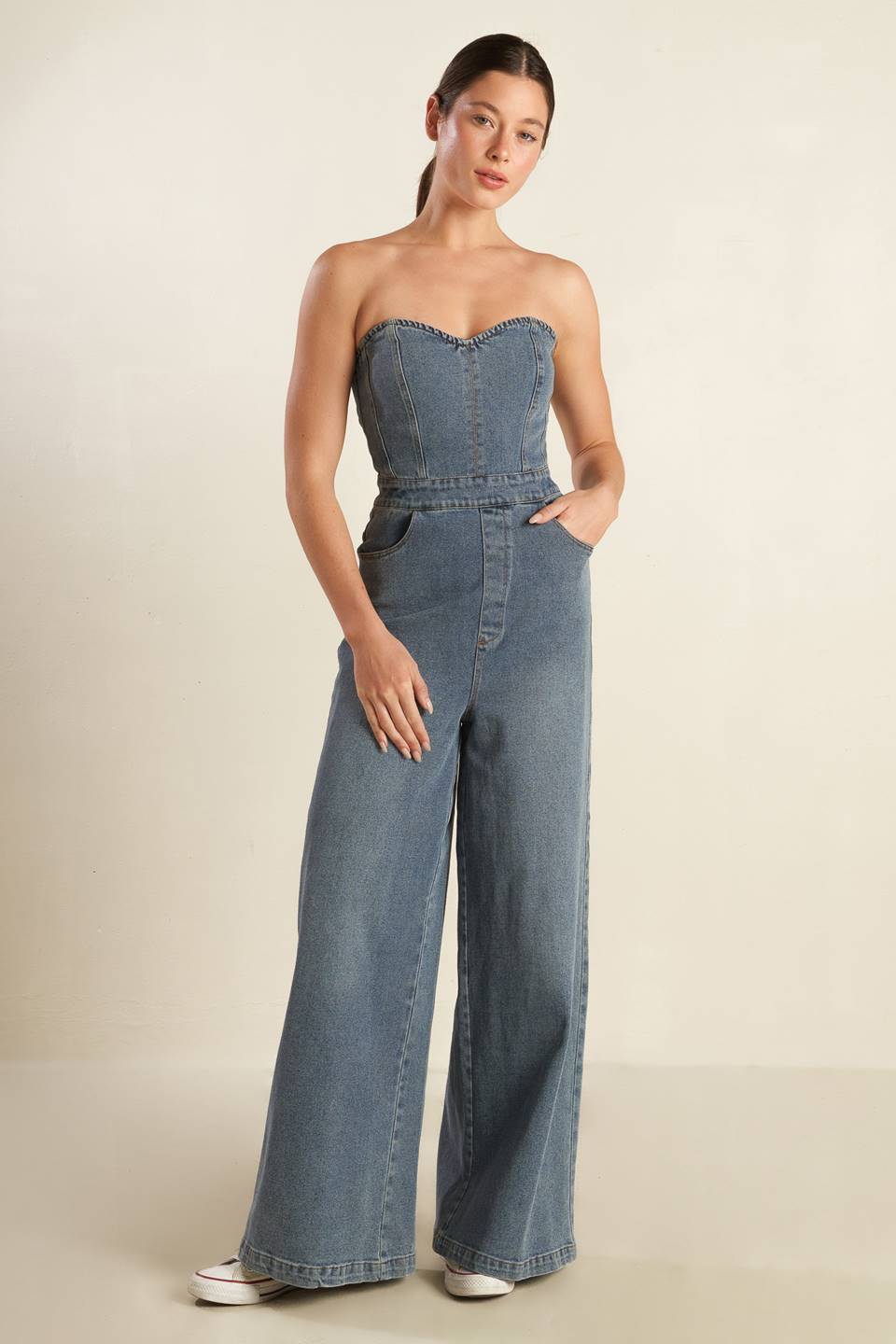 A strapless, washed blue denim jumpsuit featuring sweetheart neckline, side pockets, wide leg and back zipper closure.