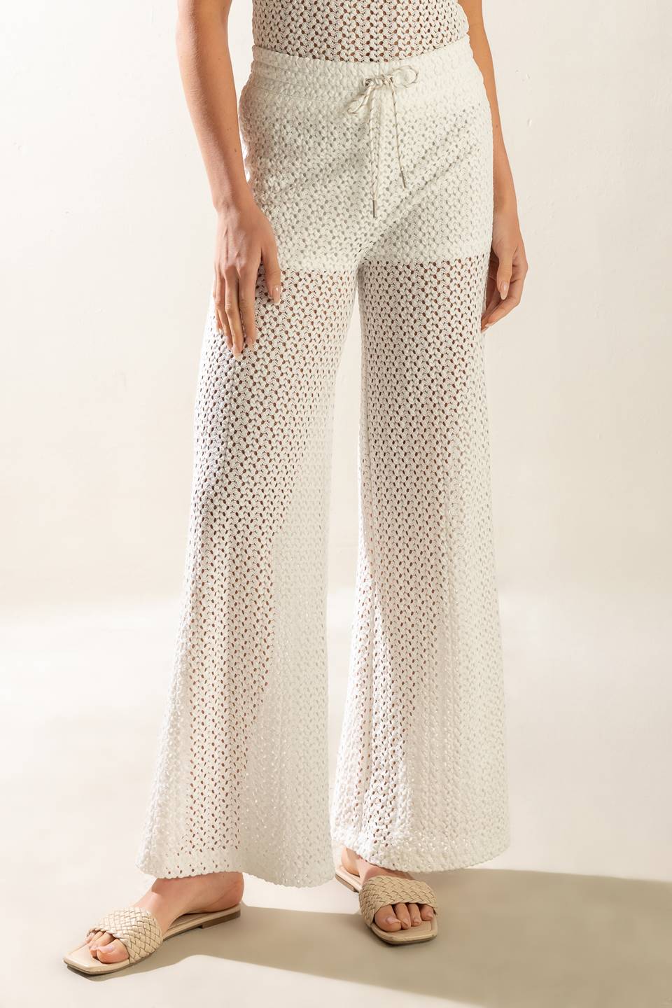 A semi sheer knit pant featuring elasticized waist band, front tie and wide leg with lining.