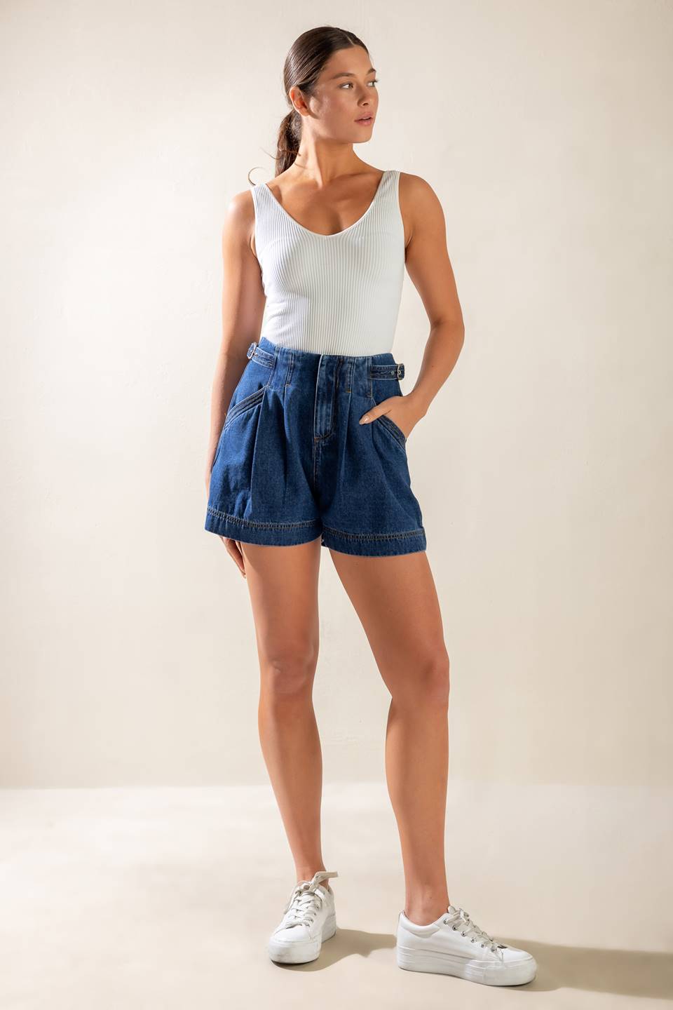 A washed denim shorts featuring front closure and pockets.