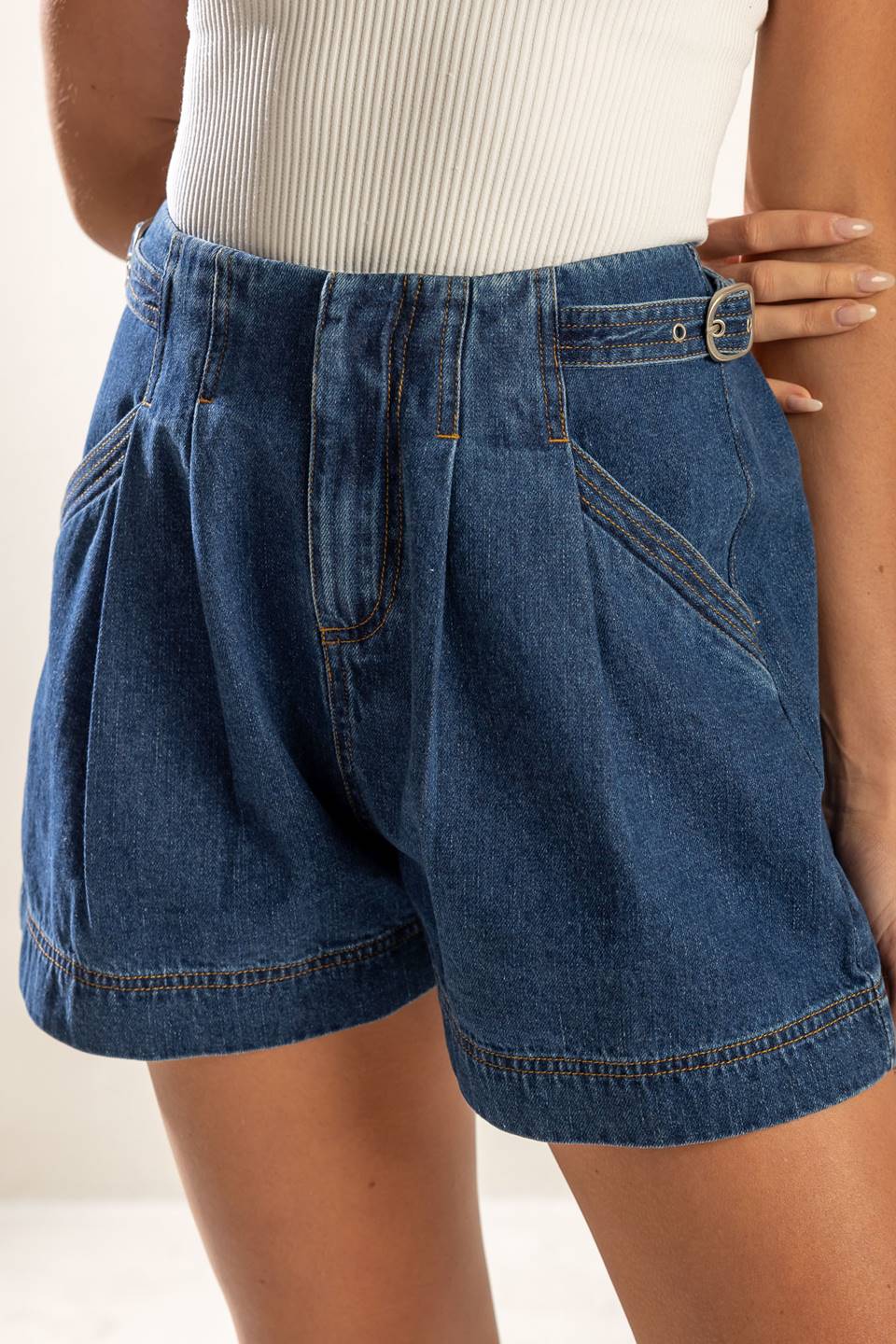 A washed denim shorts featuring front closure and pockets.