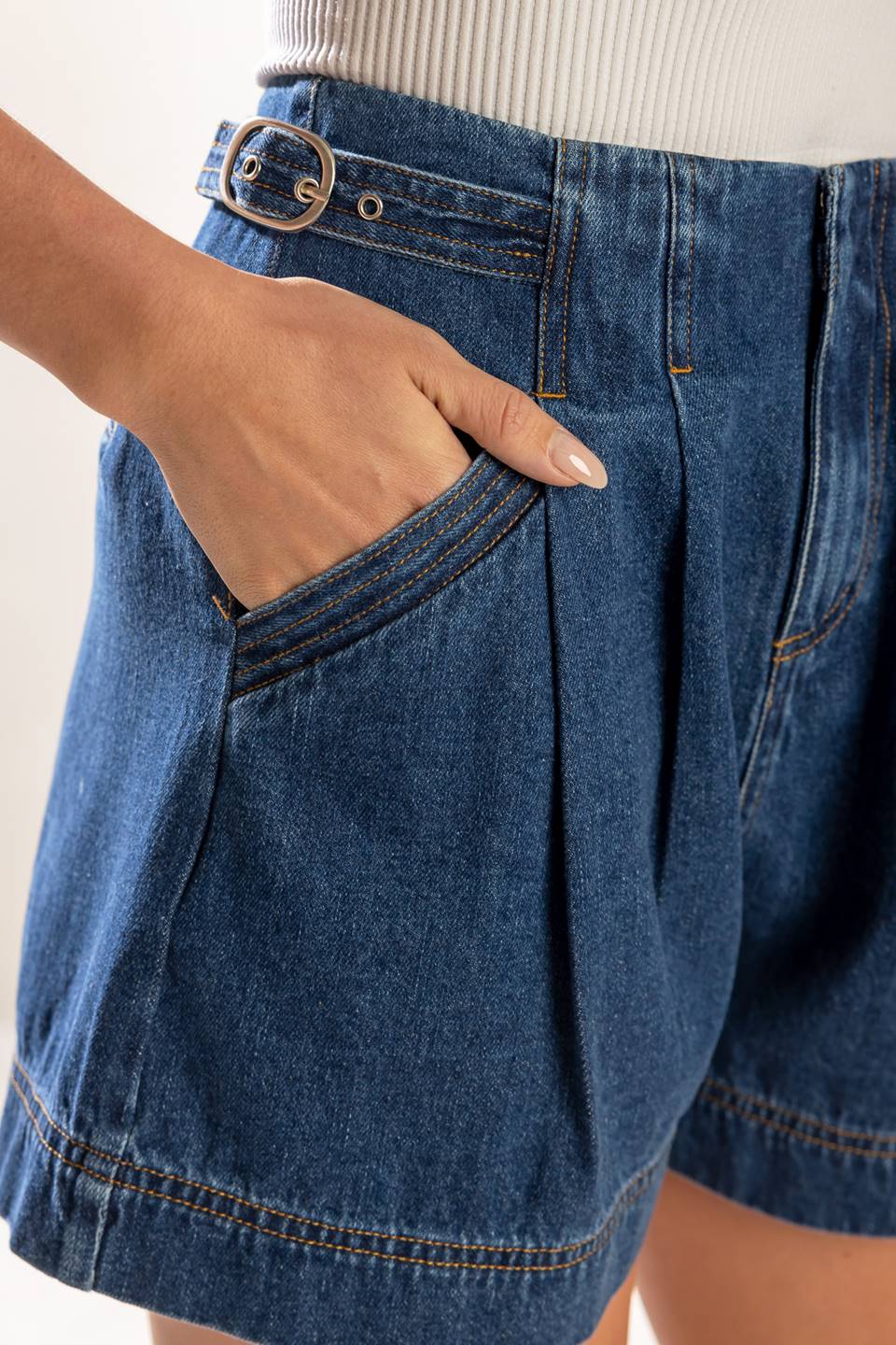 A washed denim shorts featuring front closure and pockets.