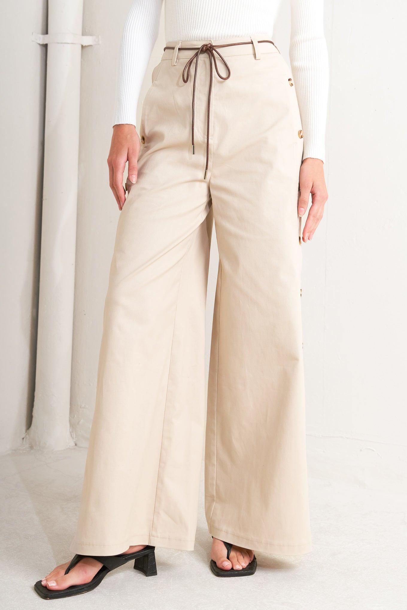 A solid woven pant featuring front closure, side button down, wide leg and skinny belt