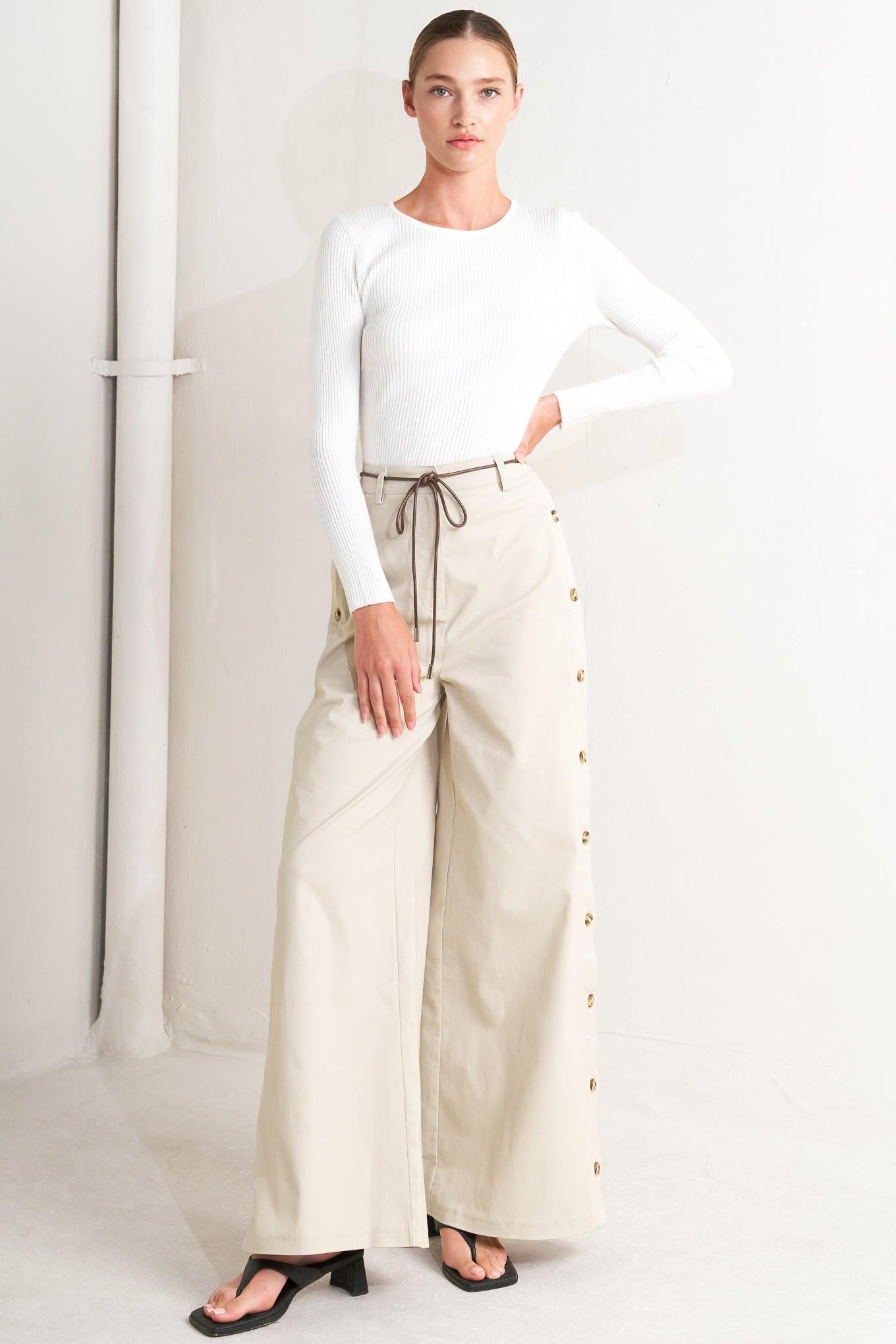 A solid woven pant featuring front closure, side button down, wide leg and skinny belt