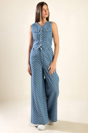 High rise, wide leg, light denim pants that feature small white bow embroidery texture, a front closure zipper, and back pockets.