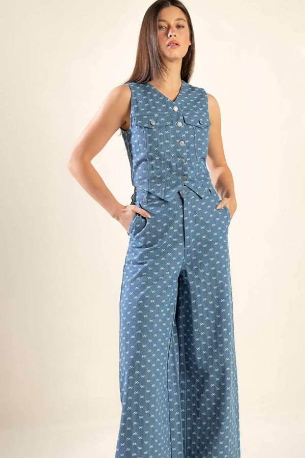 High rise, wide leg, light denim pants that feature small white bow embroidery texture, a front closure zipper, and back pockets.