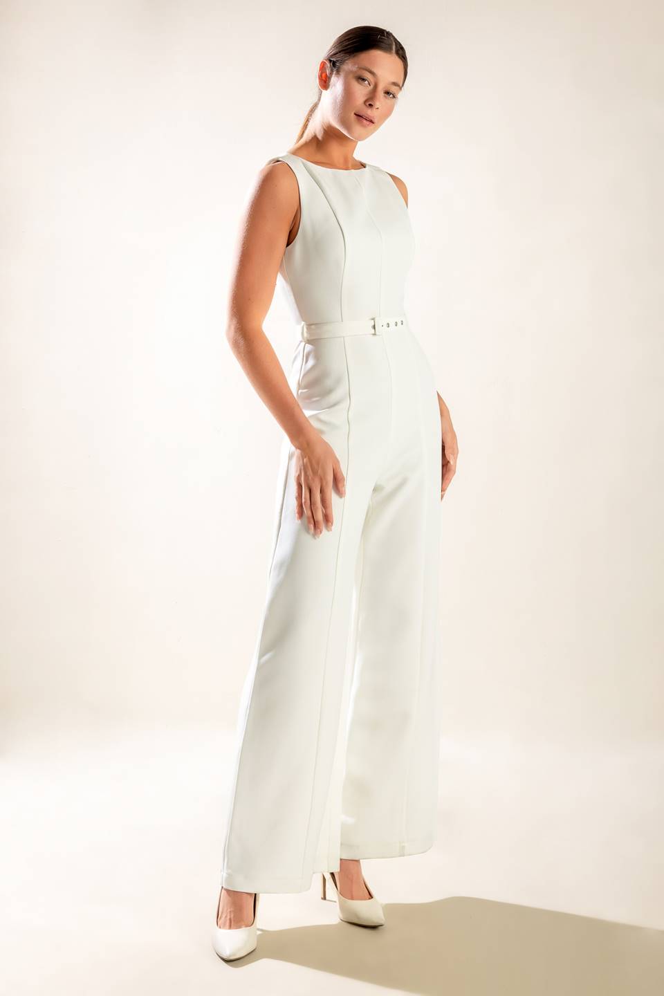 A solid woven jumpsuit featuring wide neckline, sleeveless, self belt, wide leg and back zipper closure.