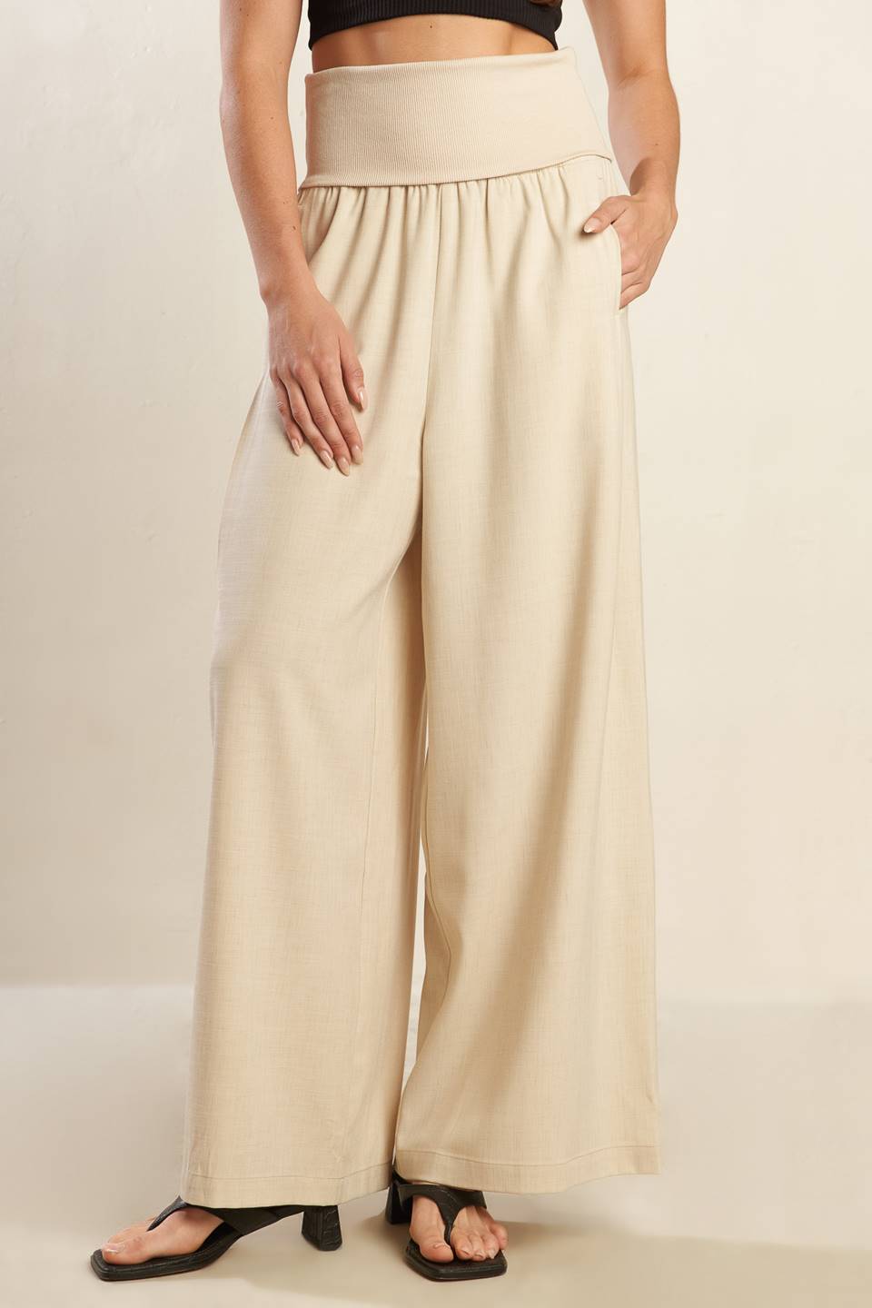 A solid beige woven pant featuring knit waist fold over and wide leg.