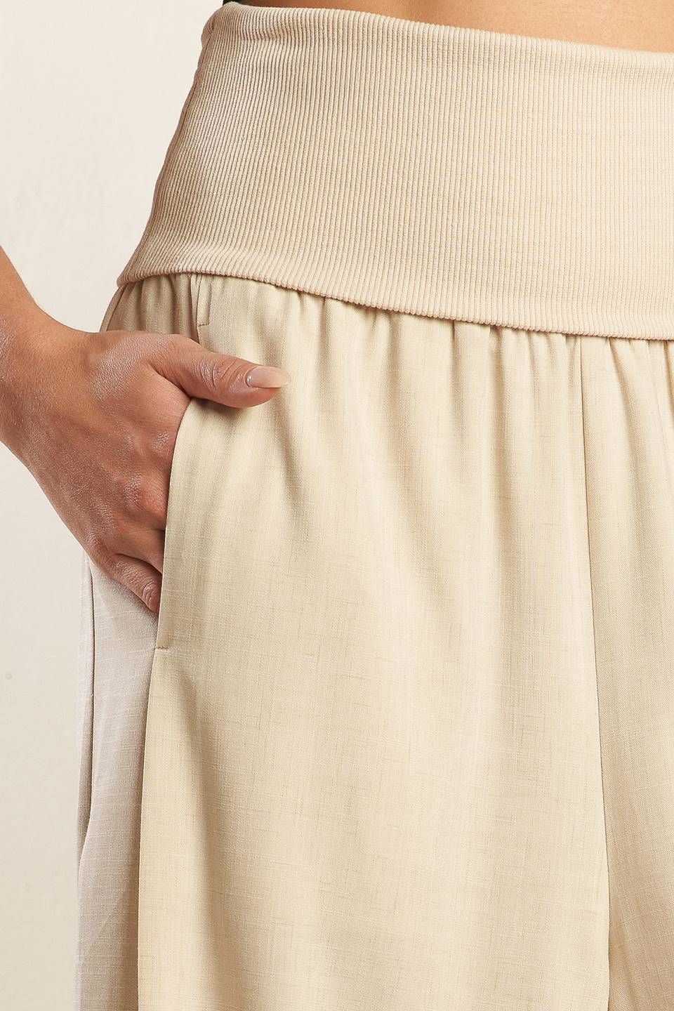 A solid beige woven pant featuring knit waist fold over and wide leg.