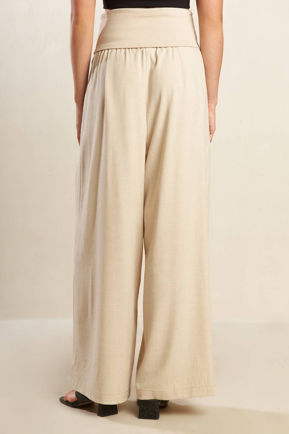 A solid beige woven pant featuring knit waist fold over and wide leg.