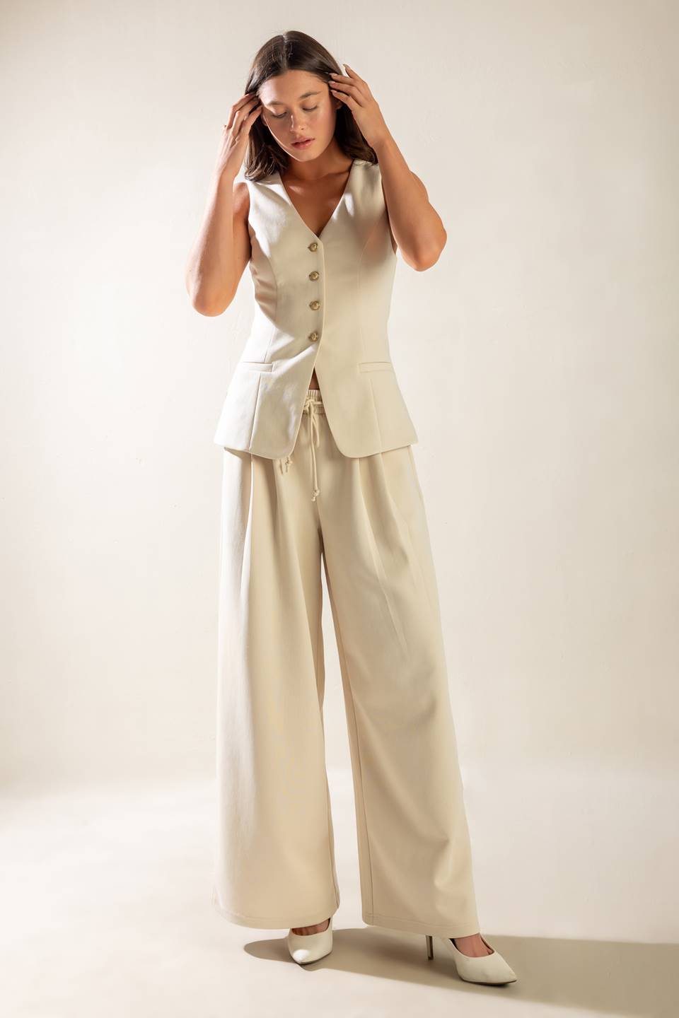 A solid wide-leg woven pant featuring elasticized waist with front tie and side pockets.