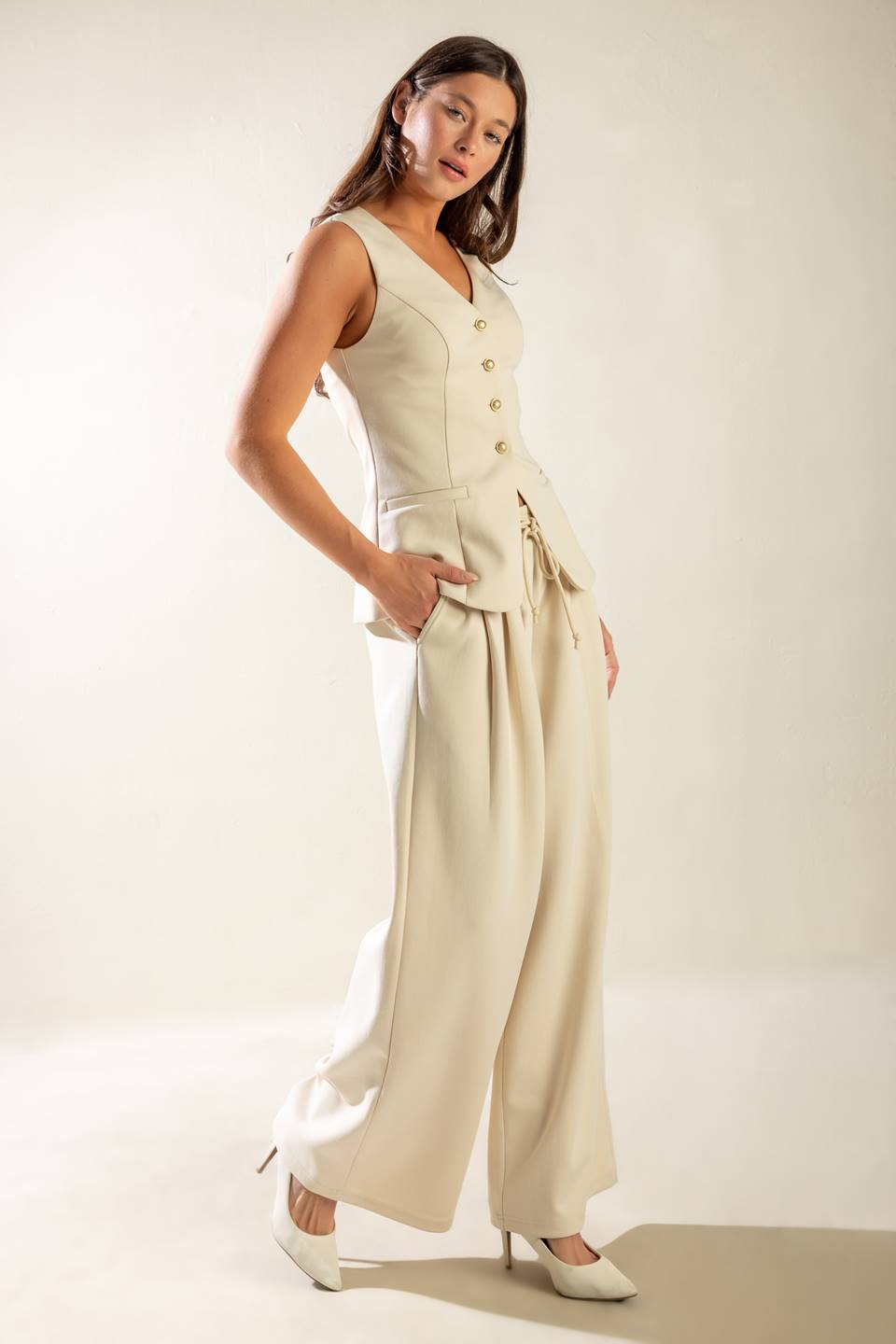 A solid wide-leg woven pant featuring elasticized waist with front tie and side pockets.