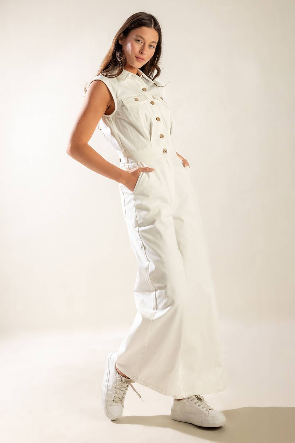 A sleeveless, solid wide-leg white woven jumpsuit featuring collar, button down and zipper closure, featuring side and back pockets.