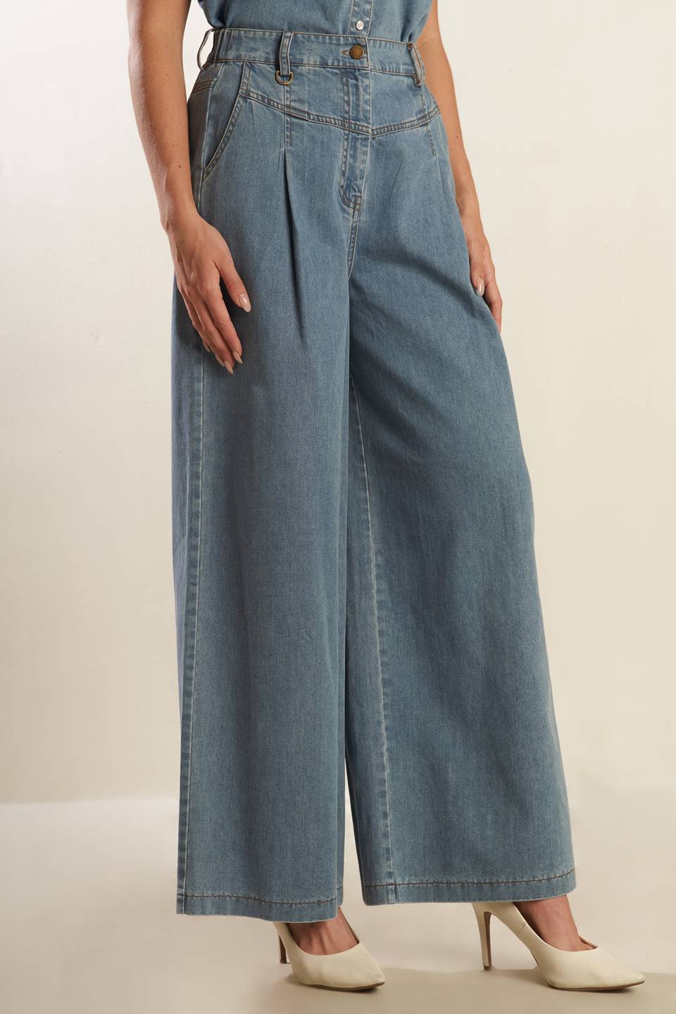 A washed light denim pant featuring front closure with self belt, side pockets, wide leg and elasticized back waistband.