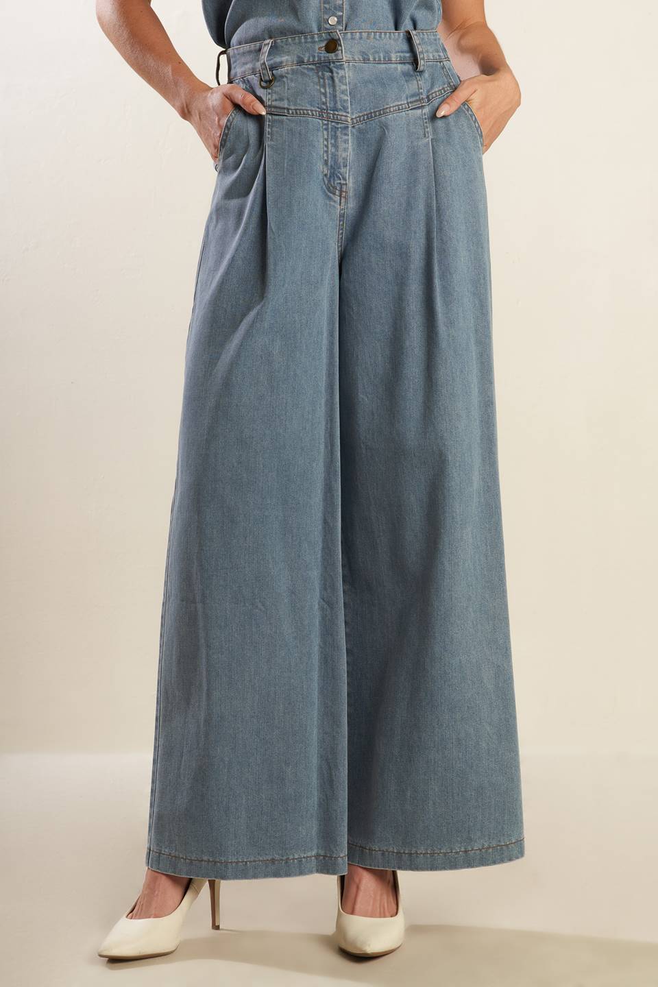 A washed light denim pant featuring front closure with self belt, side pockets, wide leg and elasticized back waistband.