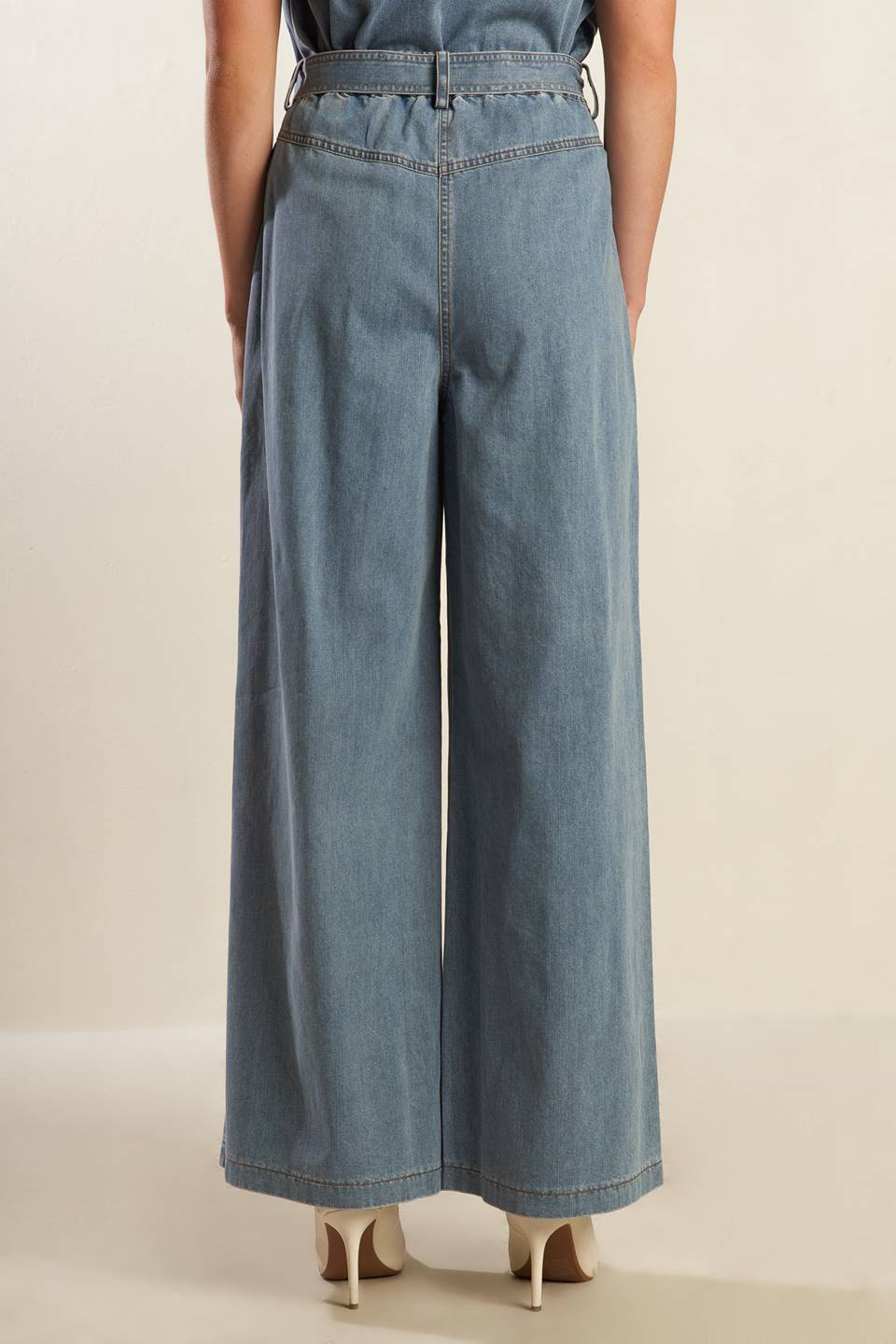 A washed light denim pant featuring front closure with self belt, side pockets, wide leg and elasticized back waistband.