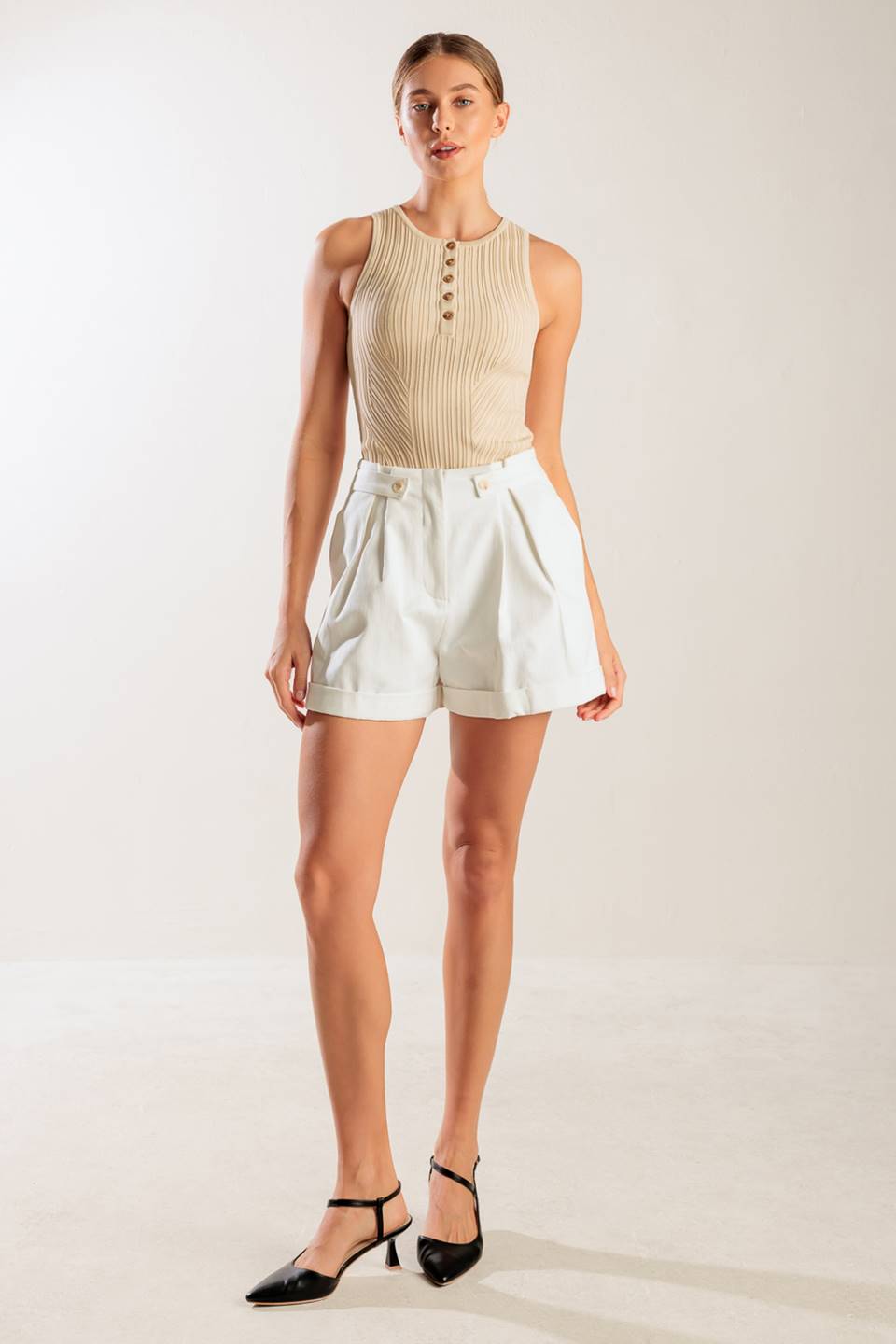 A solid woven short featuring front closure, side tab, pockets and cuffed hem