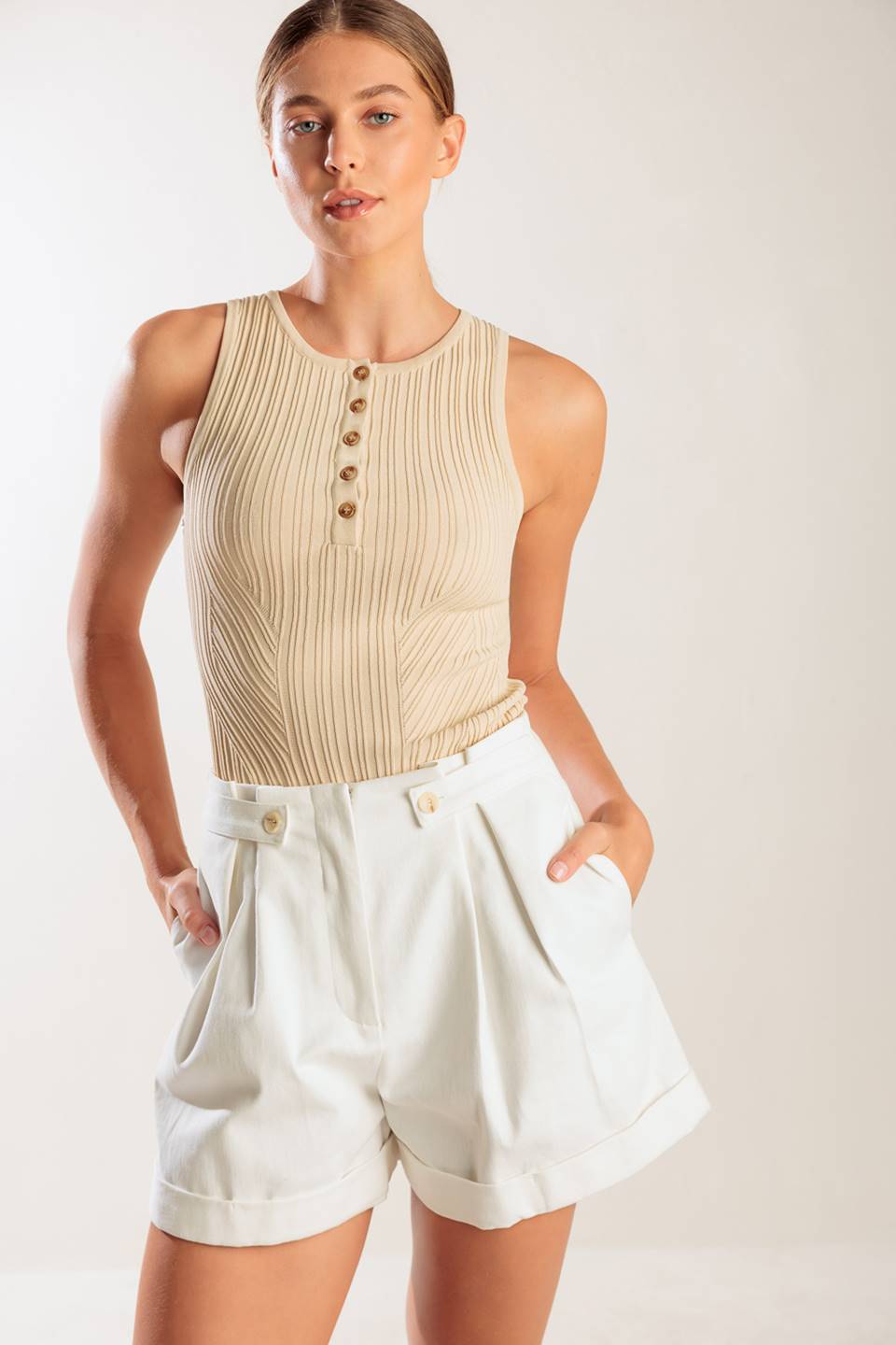 A solid woven short featuring front closure, side tab, pockets and cuffed hem